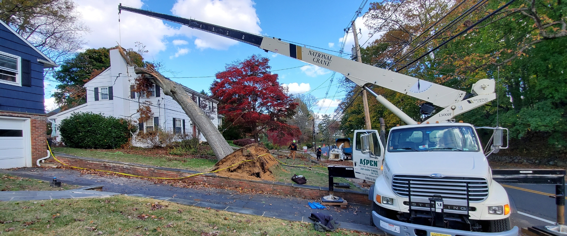 The Aspen Tree Service crane removing a fallen tree that damaged a Northern New Jersey home after a severe storm.