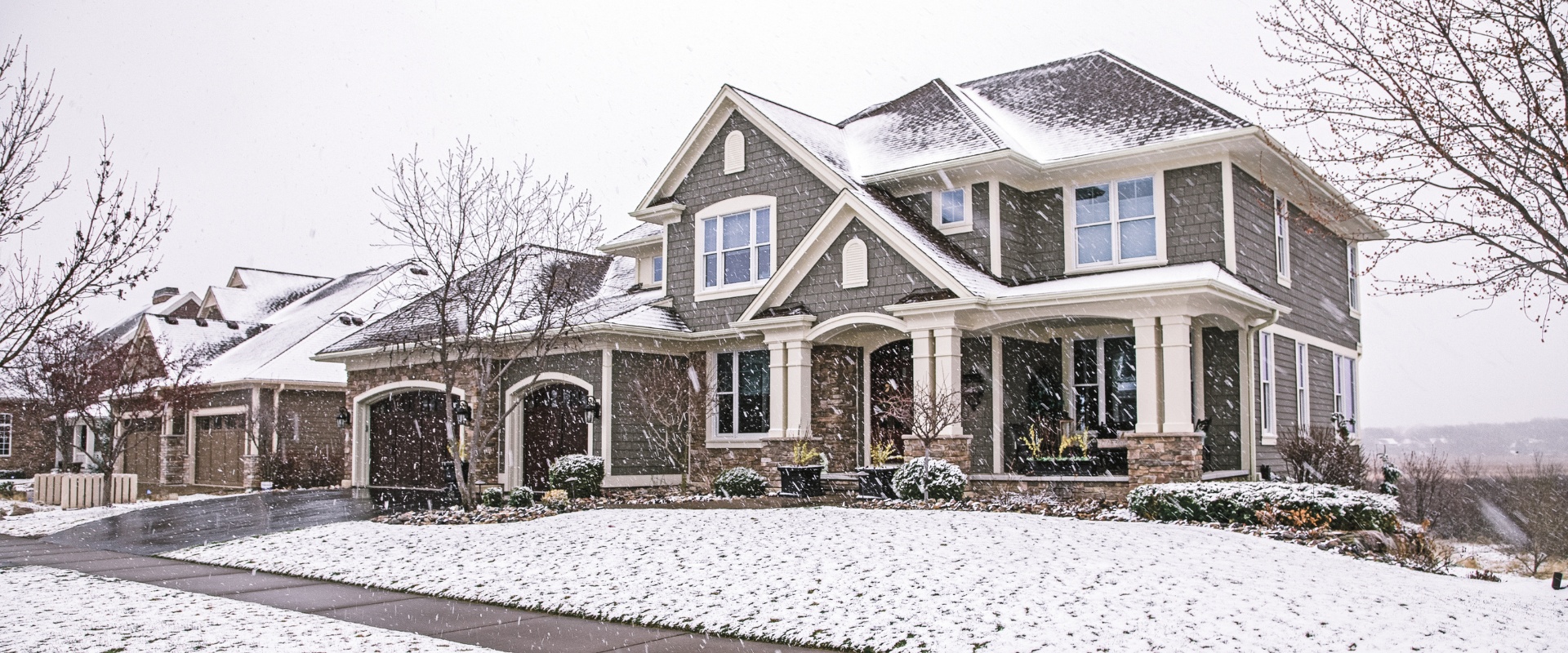 An upscale Bergen County home with mature trees in the front yard during winter, showing well-maintained landscaping that adds property value.