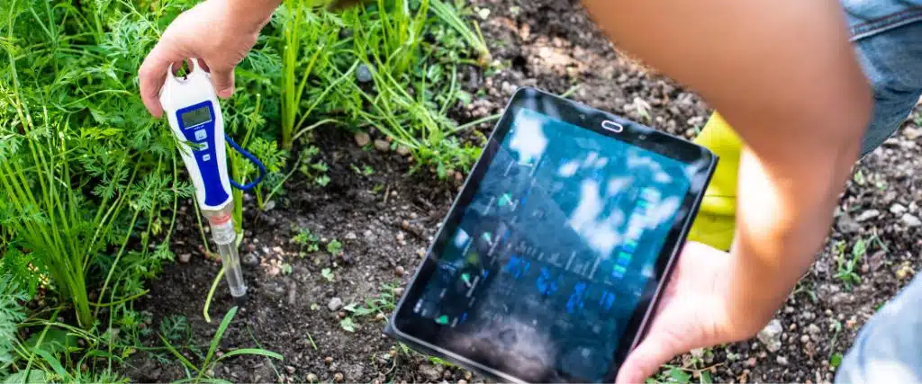 Are These Soil Problems Harming Your Trees? 2 Woman using a soil pH tester to evaluate the soil in her garden.