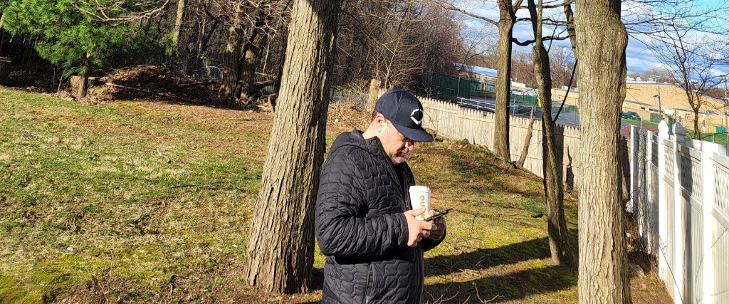 Is Bronze Birch Borer Affecting Your Birch Trees This Spring? 3 A professional arborist in winter clothing examines trees in a residential yard while taking notes during a tree health assessment.