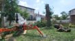 The Aspen Tree spider lift sitting near cut logs during a tree removal job in Montclair, NJ.
